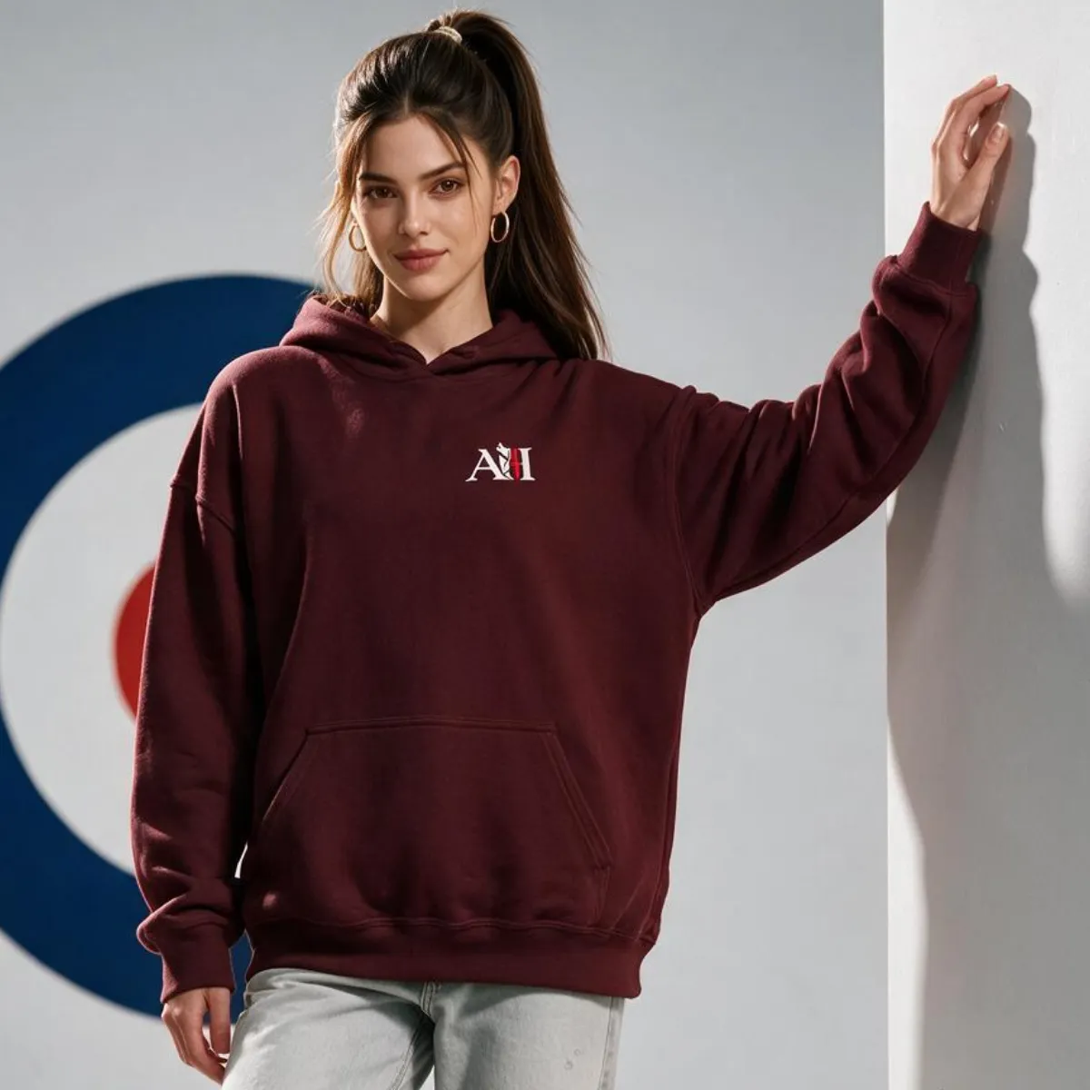 Noemié wearing an Albert Harry Fashion AH Minimal classic maroon hoodie paired with jeans and sneakers